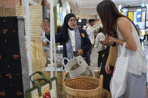 Perajin Agrominafiber melayani pembeli di antara keranjang anyaman di stan pameran