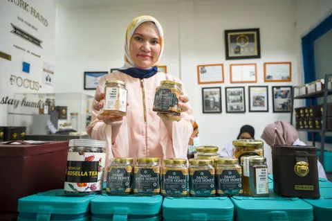 Shinta Aviyani memegang dua toples madu di depan rak produk Imago Raw Honey