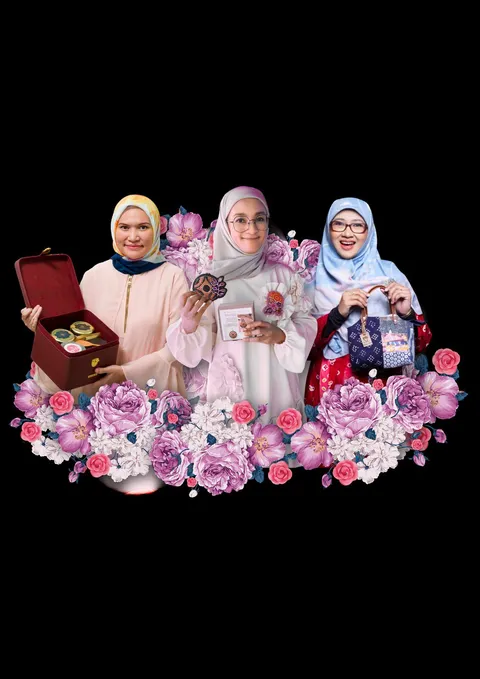 Tiga binaan perempuan berfoto bersama di balik hiasan bunga merah muda