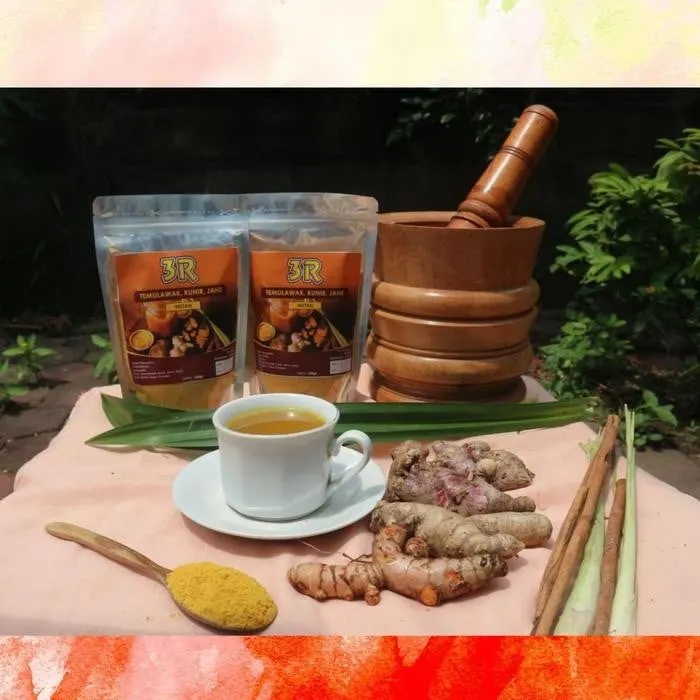 Dua kemasan 3R Temulawak, Kunir, Jahe instan dengan secangkir minuman, rimpang segar dan sendok serbuk kuning