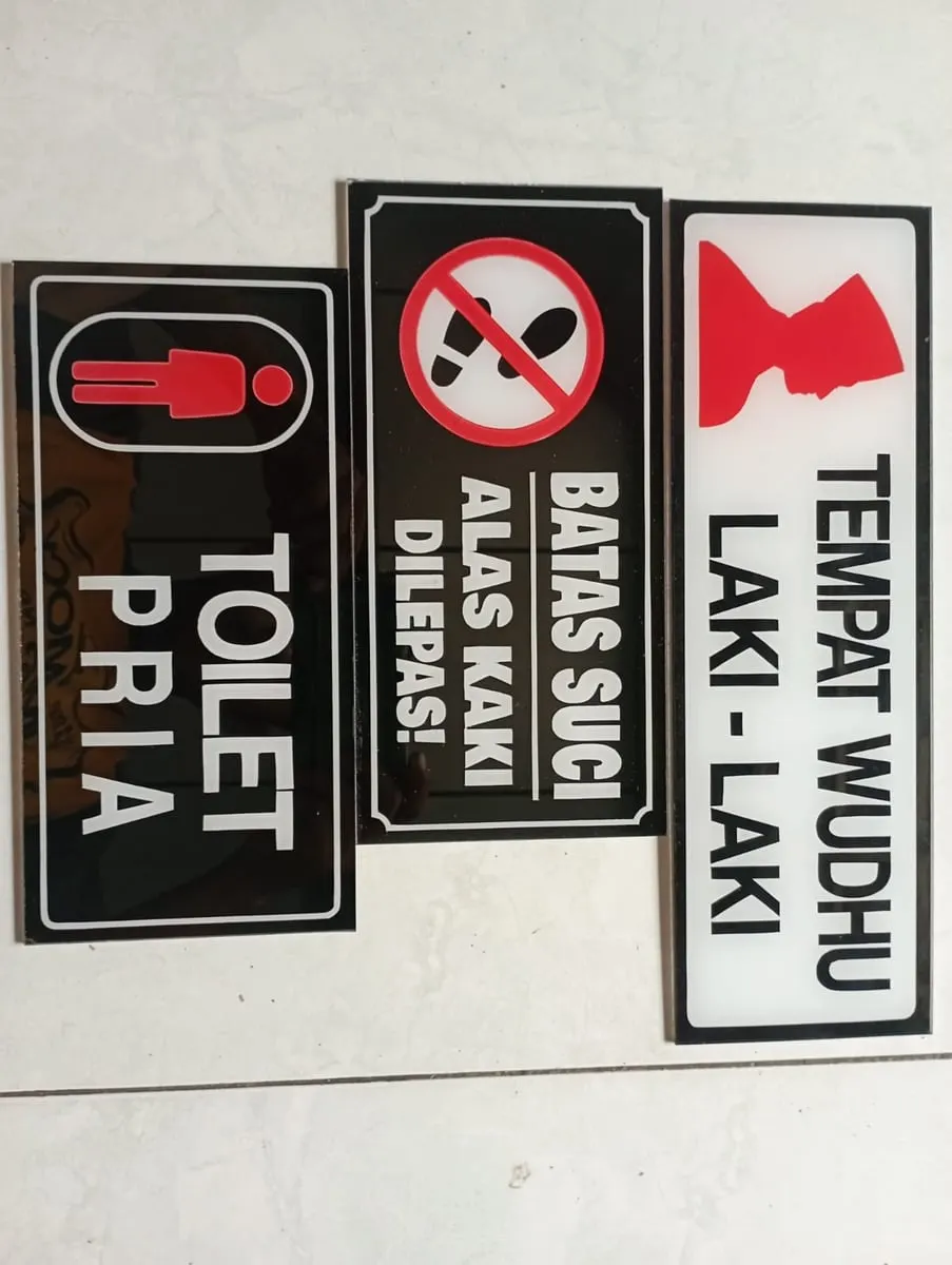 Tiga papan petunjuk akrilik hitam dan putih bertuliskan Toilet Pria, Batas Suci dan Tempat Wudhu Laki-Laki