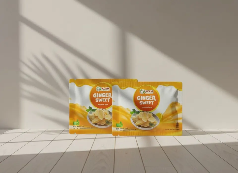 Dua kemasan sachet oranye Ginger Sweet bergambar irisan jahe di lantai kayu putih