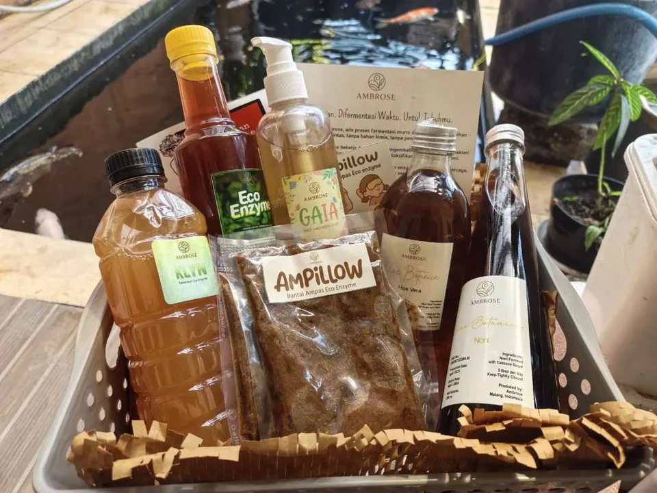 Keranjang berisi botol cuka fermentasi Ambrose, Eco Enzyme, sabun Gaia, karbol Klyn dan kemasan Ampillow di tepi kolam