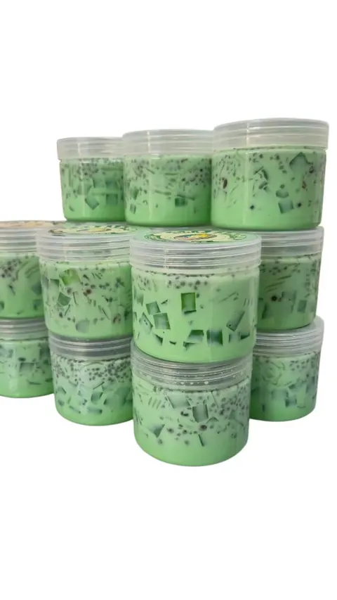 Tumpukan cup plastik berisi dessert hijau dengan potongan jeli dan biji selasih