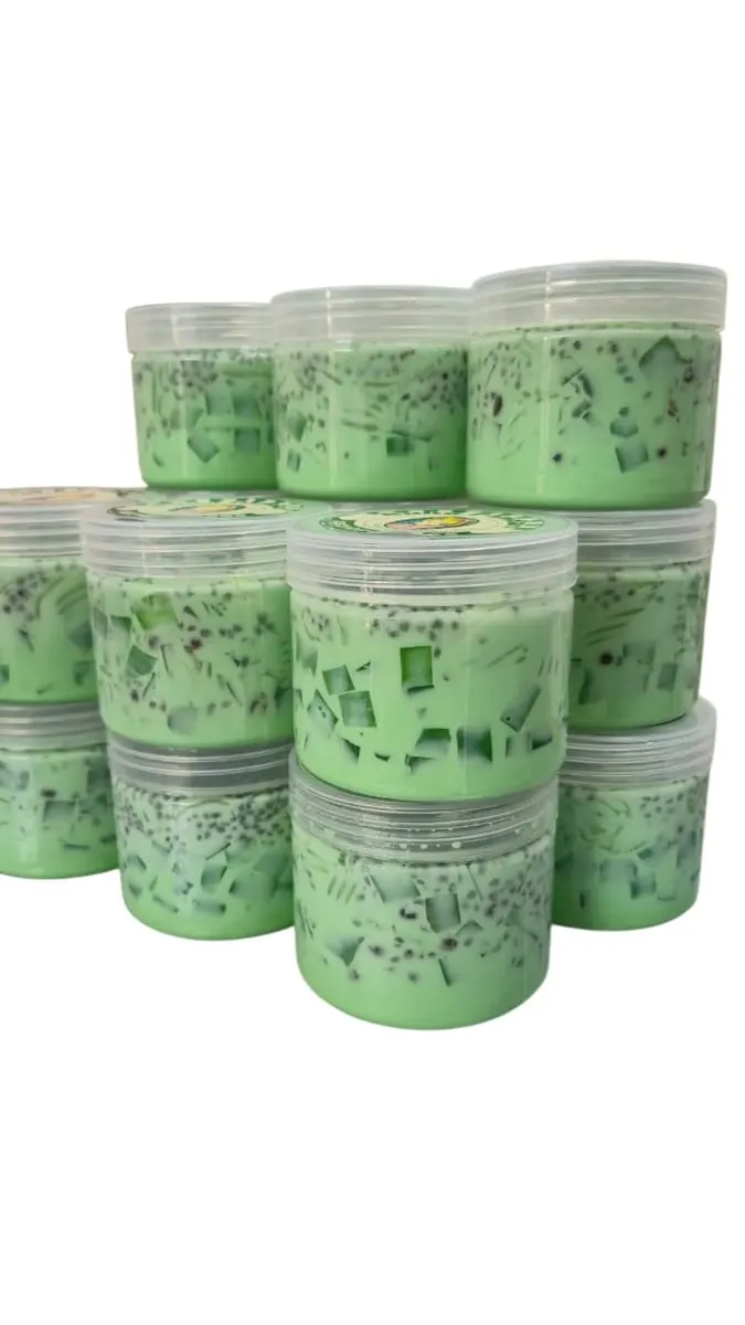 Tumpukan cup plastik berisi dessert hijau dengan potongan jeli dan biji selasih