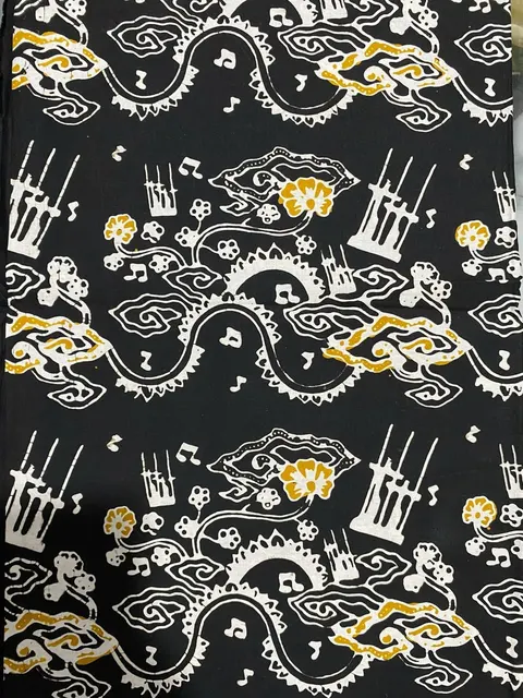Kain batik hitam bermotif angklung, not balok dan awan berwarna putih dan kuning