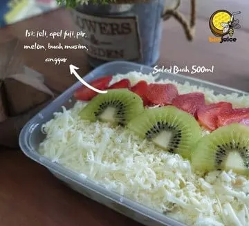 Salad buah dalam wadah 500 ml bertabur keju parut, kiwi dan stroberi dengan tulisan daftar isi