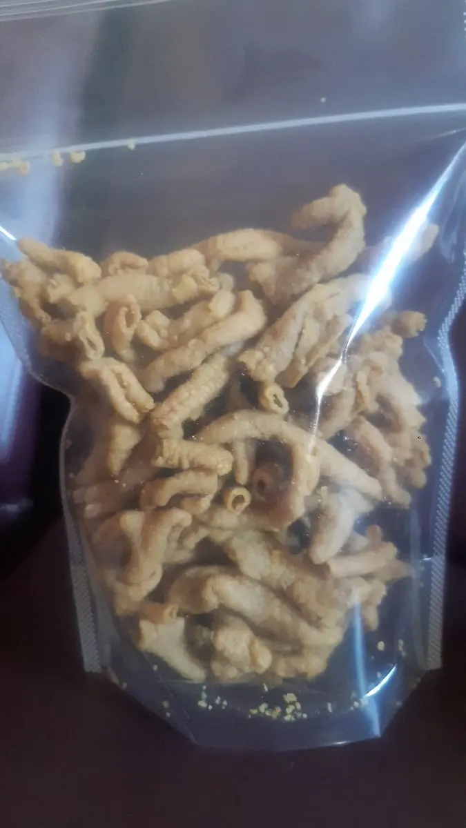 Camilan goreng renyah berbentuk keriting dalam kemasan standing pouch plastik bening