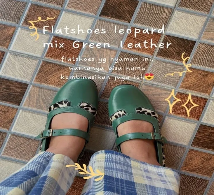 Kaki memakai flatshoes kulit hijau bertali dengan aksen motif leopard di lantai keramik