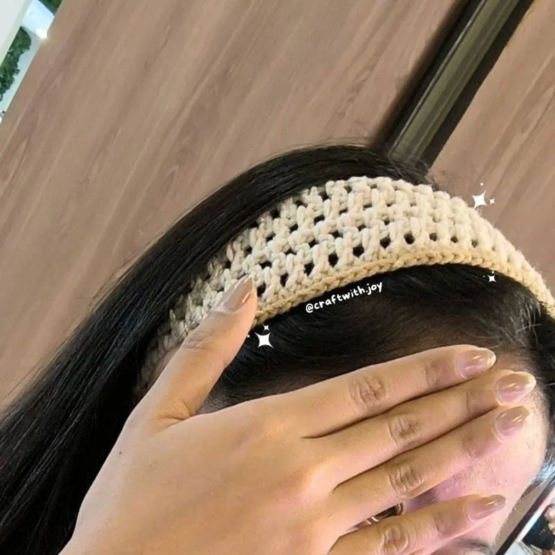 Bando rajut krem bermotif jaring dipakai di kepala berambut hitam panjang