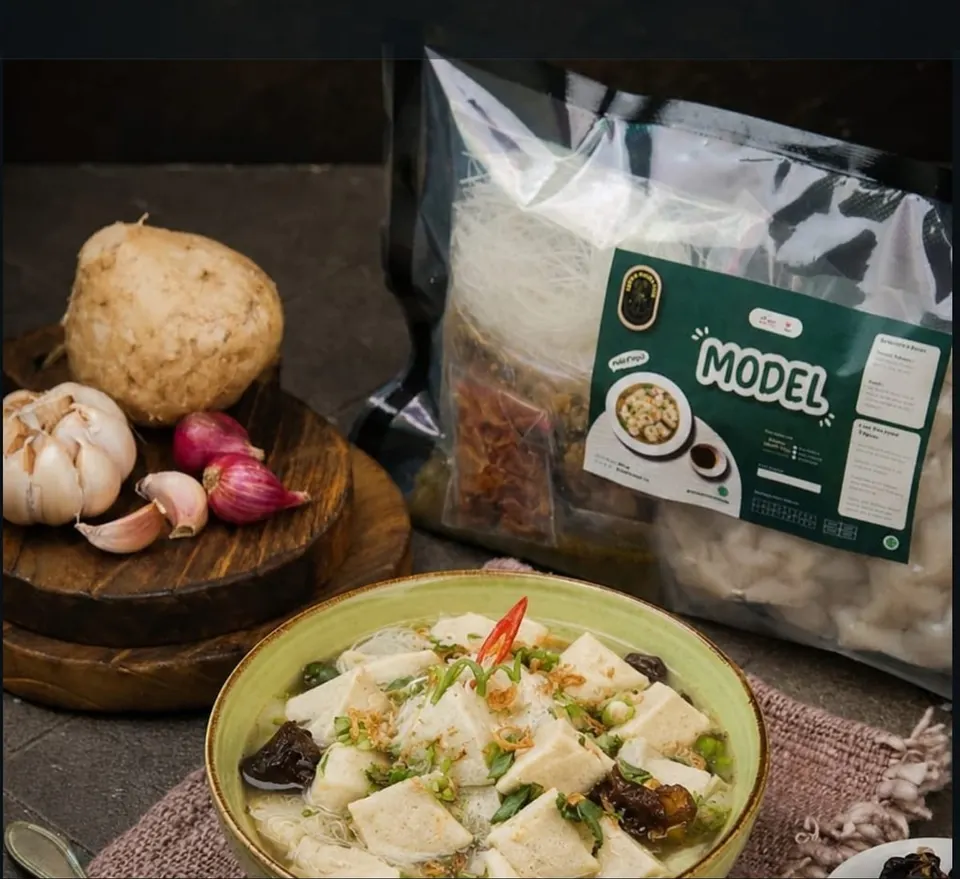 Semangkuk model berkuah dengan bihun dan daun bawang di depan kemasan Model Dapur Mami Nita dan bengkuang