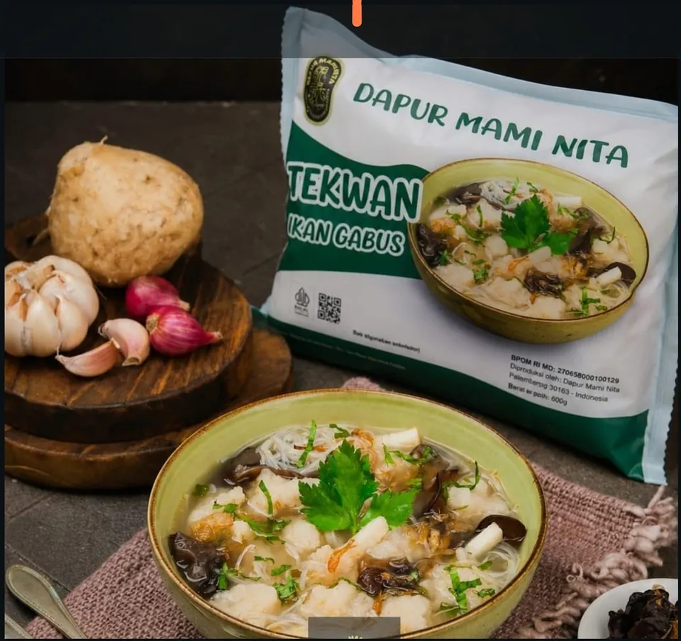 Semangkuk tekwan berkuah dengan jamur kuping di depan kemasan Tekwan Ikan Gabus Dapur Mami Nita