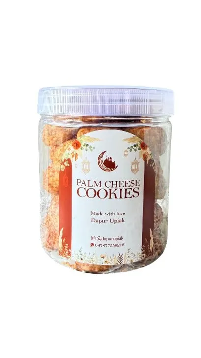 Toples plastik Palm Cheese Cookies berisi kue kering keju dengan label merah putih Dapur Upiak