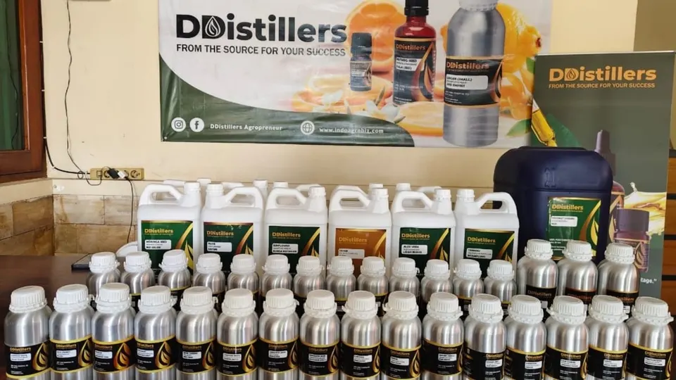 Deretan botol aluminium dan jeriken putih berlabel DDistillers di depan spanduk merek DDistillers