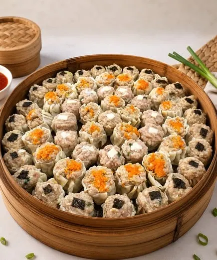 Puluhan dimsum siomay bertabur topping oranye dan nori dalam kukusan bambu besar