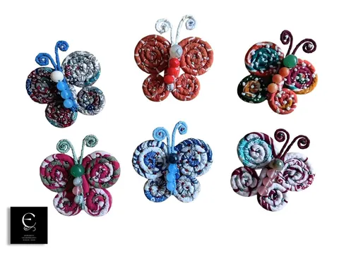 Enam bros kupu-kupu dari gulungan kain batik aneka warna dengan manik di latar putih