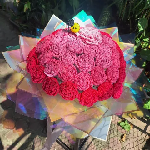 Buket bunga mawar rajut merah dan merah muda dibungkus kertas hologram