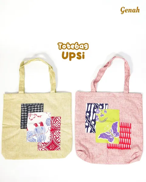 Dua tas jinjing kain krem dan merah muda dengan tempelan potongan kain motif, bertuliskan Totebag Upsi