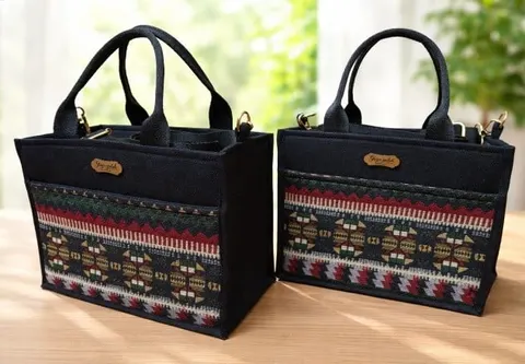 Dua tas tangan kanvas hitam dengan panel tenun motif merah hijau dan label kulit kecil