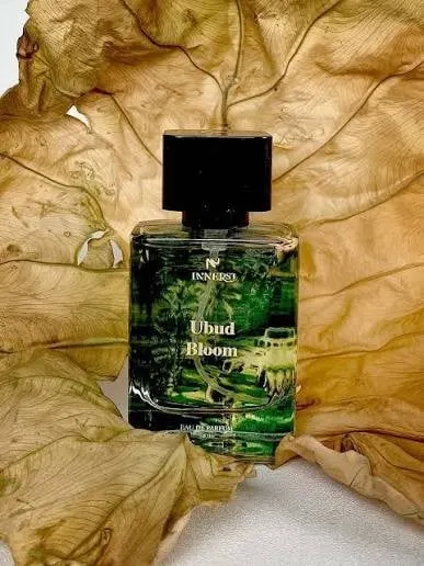 Botol parfum Innerst Ubud Bloom bertutup hitam dengan motif hutan hijau, berlatar daun kering