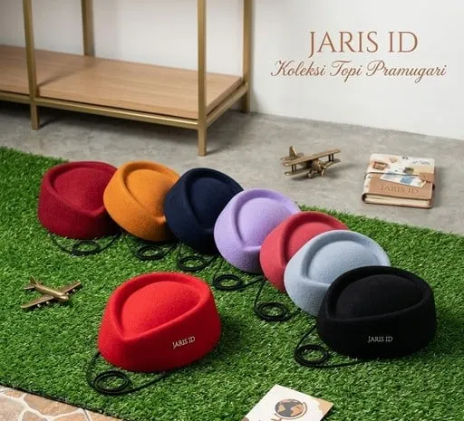Deretan topi pramugari aneka warna bertulisan JARIS ID di atas rumput sintetis