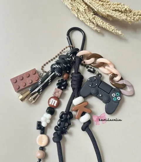 Bag charm bertali hitam dengan hiasan balok mainan, stik game, rantai merah muda dan manik huruf