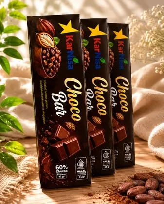 Tiga kotak cokelat tua KarNisa Choco Bar 60% kakao, berat 41 gram, dengan biji kakao di depannya