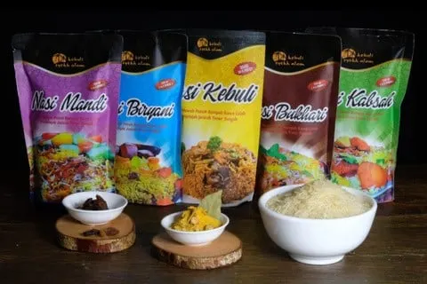 Lima pouch warna-warni Nasi Mandi, Biryani, Kebuli, Bukhari, dan Kabsah dengan mangkuk beras dan bumbu