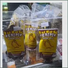 Kemasan kecil Keripik Pisang Lala berlabel kuning bergambar pisang tersusun di etalase kaca