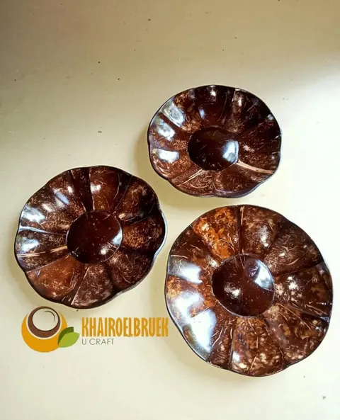 Tiga piring batok kelapa berbentuk bunga dengan permukaan cokelat mengilap di atas alas krem