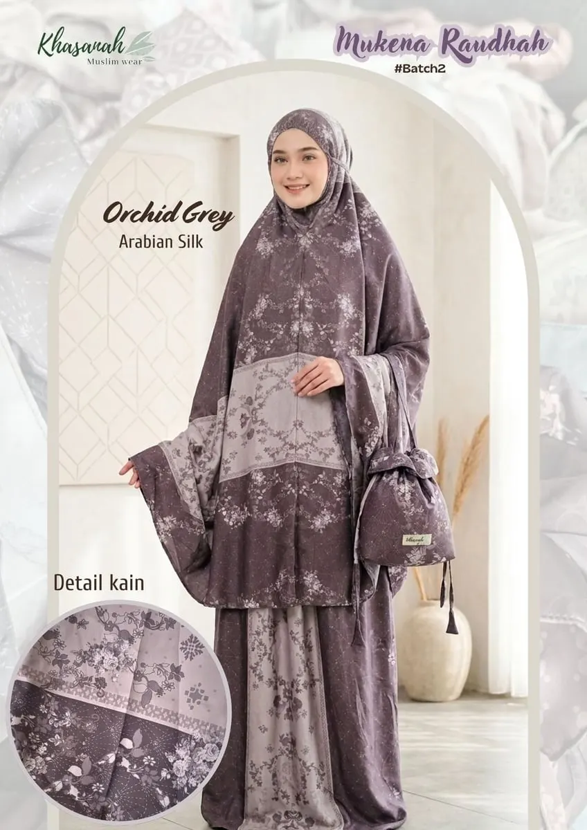 Model memakai mukena ungu keabuan motif bunga dengan tas serut senada, berlabel Mukena Raudhah Orchid Grey