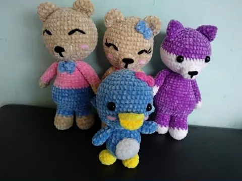 Empat boneka amigurumi berbahan rajut, dua beruang, kucing ungu dan penguin biru