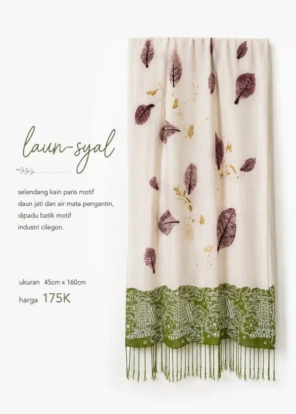 Selendang putih bermotif daun ungu dengan ujung batik hijau berumbai, bertuliskan laun-syal 175K