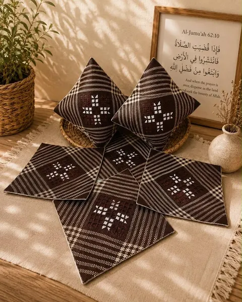 Dua bantal dan empat sarung bantal persegi anyaman pandan cokelat tua bermotif bunga putih di atas kain krem