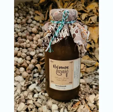 Botol kaca jamu Temulawak berlabel Ngramu dengan tutup kain batik, di atas tumpukan rempah kering
