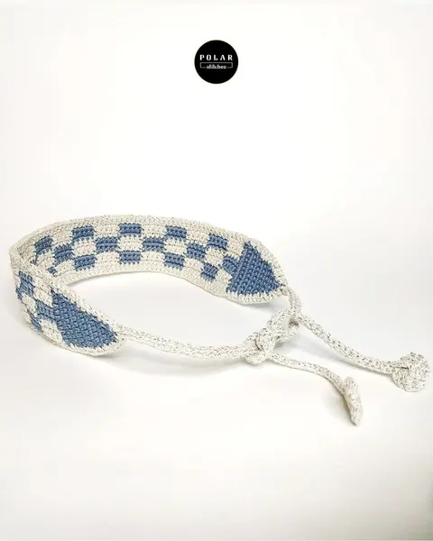 Gelang rajut motif kotak-kotak biru dan putih dengan tali pengikat di latar putih