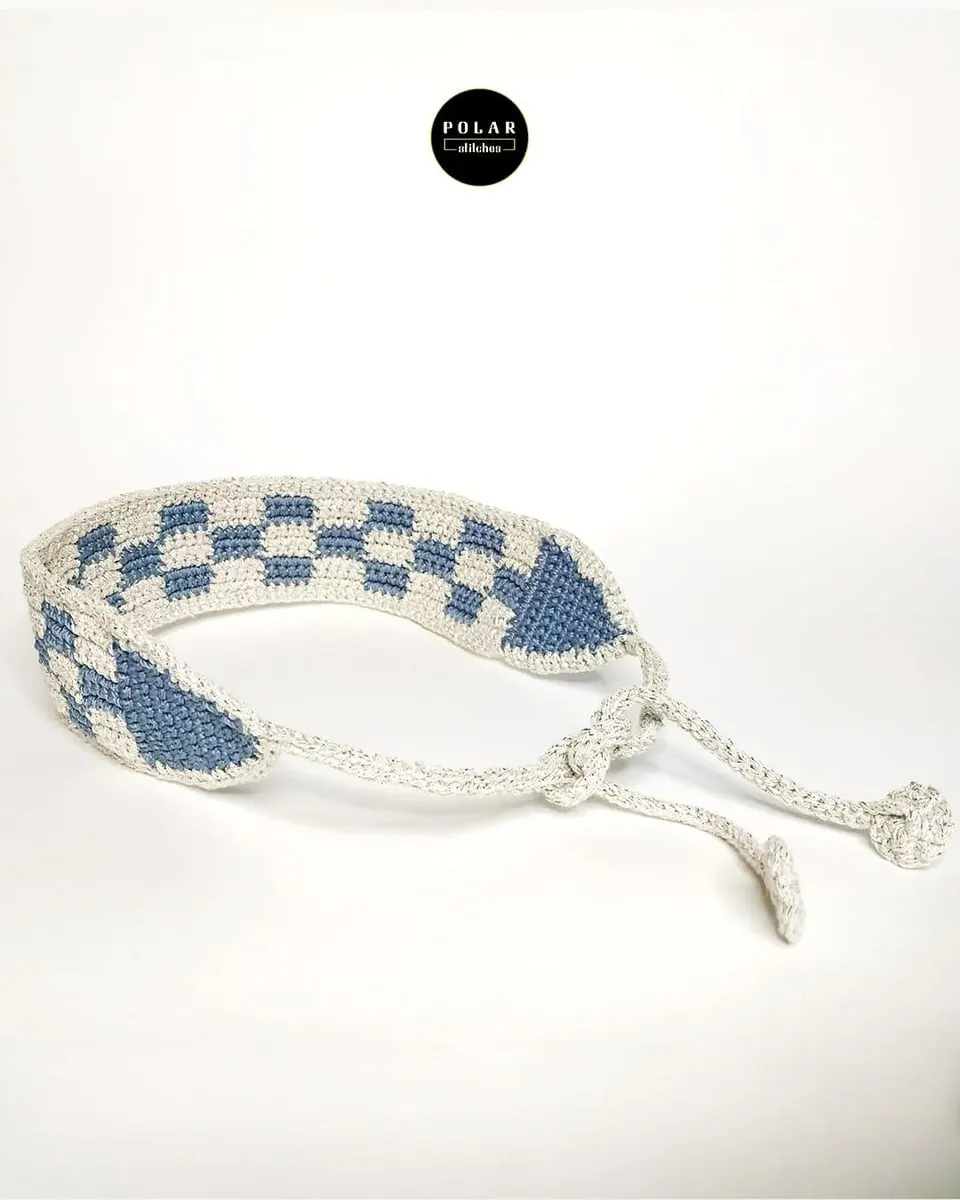 Gelang rajut motif kotak-kotak biru dan putih dengan tali pengikat di latar putih