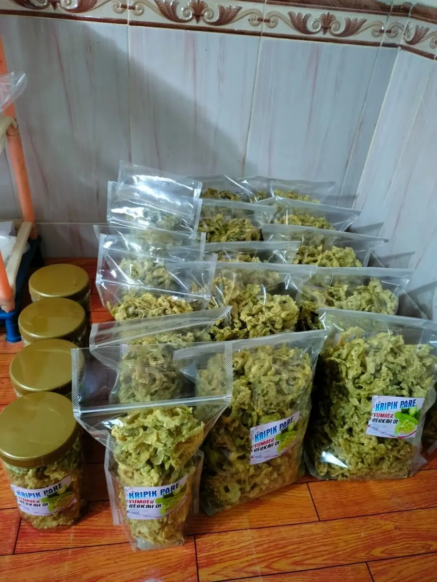Puluhan kantong plastik dan beberapa toples bertutup emas berisi keripik pare berlabel Kripik Pare