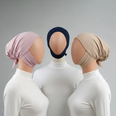 Tiga dalaman hijab model ciput warna merah muda, biru dongker dan krem pada manekin berbaju putih