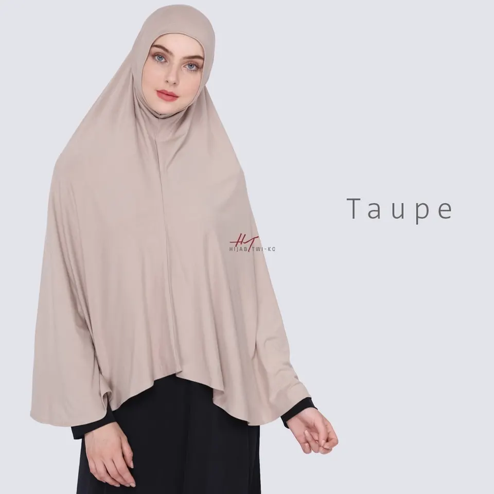 Model memakai hijab instan panjang warna taupe yang menutup dada dan lengan, dengan label warna Taupe