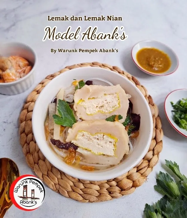 Semangkuk model berisi pempek isi tahu dalam kuah bening dengan bihun dan seledri, bertulisan Model Abank's