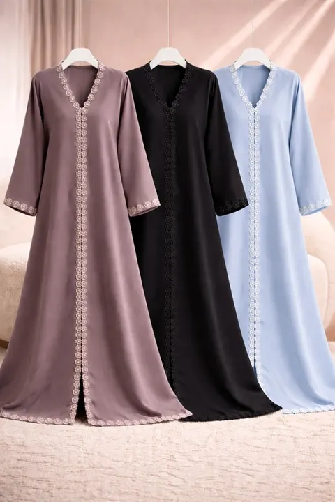 Tiga abaya berwarna mauve, hitam dan biru muda berhias renda di sepanjang bagian depan, tergantung di hanger