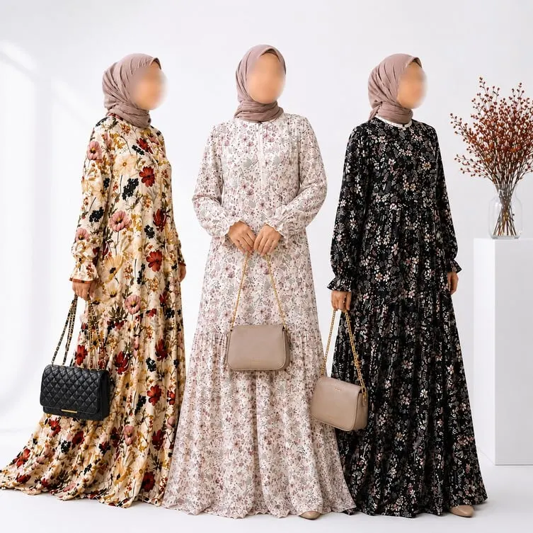 Tiga model berhijab mengenakan gamis bermotif bunga warna krem, putih dan hitam sambil membawa tas tangan